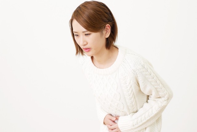 おなかをおさえる女性